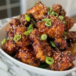 ['Close-up of golden-brown Air Fryer Korean Fried Chicken pieces garnished with scallions and sesame seeds.', 'Juicy, crispy Air Fryer Korean Fried Chicken served in a bowl with a glossy sauce and sprinkled sesame seeds.', 'Side view of succulent Air Fryer Korean Fried Chicken showcasing its crunchy texture and rich color.', 'Appetizing close-up of crispy Korean Fried Chicken, highlighting its fried coating and fresh scallions.']