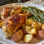 ['Juicy chicken thighs with golden potatoes and green beans in a rustic presentation.', 'Close-up view of a complete chicken dinner featuring chicken, potatoes, and vegetables.', 'A plate of baked chicken thighs surrounded by diced Yukon gold potatoes and fresh green beans.', 'Succulent chicken dinner with vibrant green beans, potatoes, and a rich tomato sauce.']