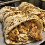 ['Close-up side view of juicy chicken gyros served with fresh toppings.', 'Detailed shot of high protein chicken gyros with a colorful garnish.', 'Side view of a succulent chicken gyro showcasing its ingredients.', 'Close-up image of a delicious chicken gyro with a creamy sauce.']