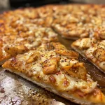 ['Close-up of a slice of Hot Honey Chicken Pizza drizzled with hot honey.', 'Side view of a freshly baked Hot Honey Chicken Pizza with melted cheese.', 'Juicy Hot Honey Chicken Pizza topped with chicken and a golden drizzle.', 'Delicious Hot Honey Chicken Pizza featuring a crispy crust and gooey mozzarella.']