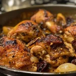 ['Close-up side view of crispy, juicy Oven Baked Moroccan Chicken garnished with olives and prunes.', 'Appetizing photo of baked chicken thighs with a Moroccan spice blend, featuring preserved lemons.', 'Juicy chicken dish with a golden-brown exterior, showcasing rich spices and colorful ingredients.', 'Detail shot of Oven Baked Moroccan Chicken, highlighting crispy skin and vibrant garnishes.']