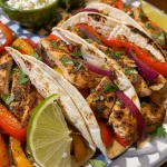Close-up view of creamy chicken fajitas on a plate with vibrant bell peppers.