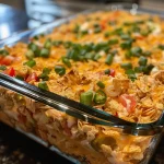 Close-up view of a crunchy chicken casserole topped with cheese and green onions.
